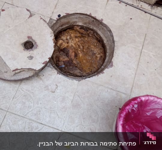 פתח ביוב פתוח עם מכסה שבור על רצפה